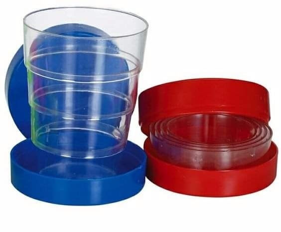 Vasos plegables transparentes con su caja azul y roja.