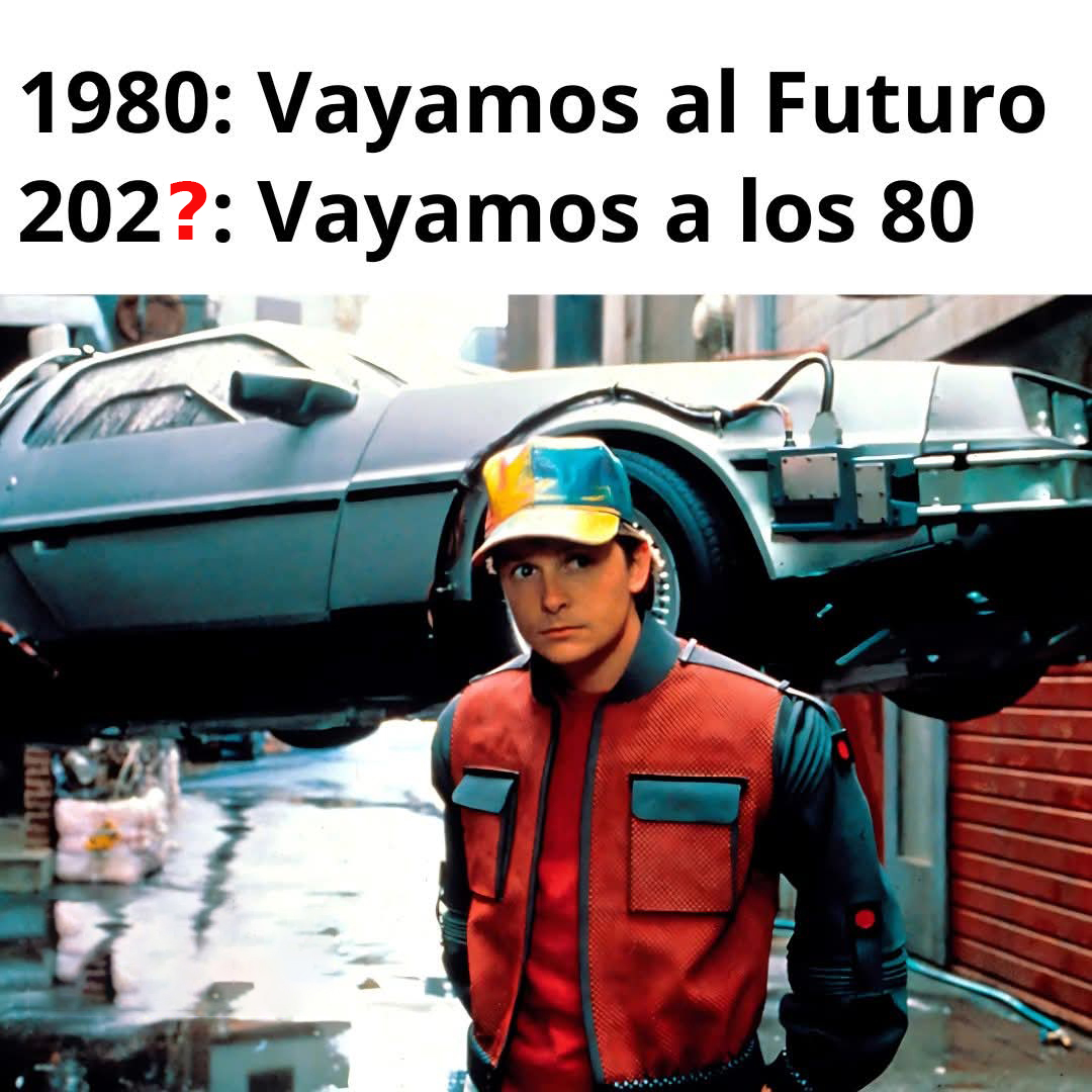 Marty McFly con gorra de colores y chaqueta roja delante del DeLorean elevado.