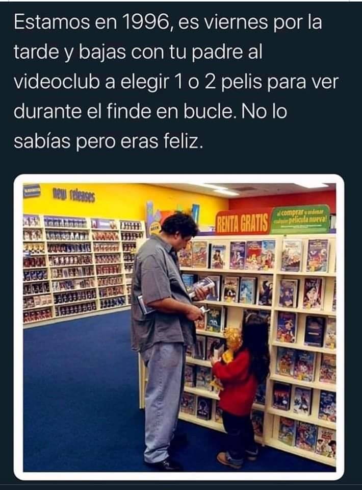 Padre e hija eligiendo películas en las estanterías de un videoclub.